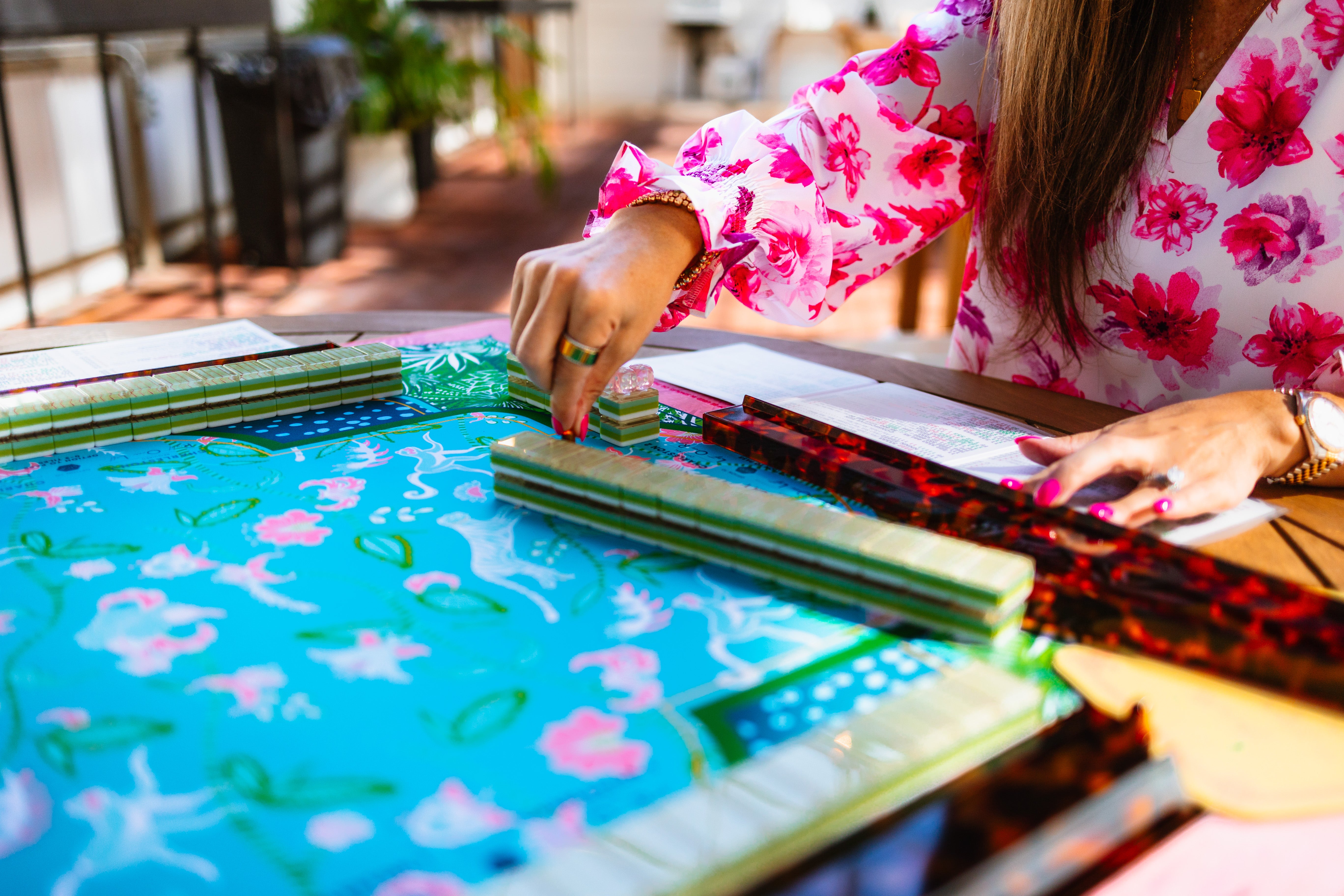 Lara playing American mahjong at a colorful table